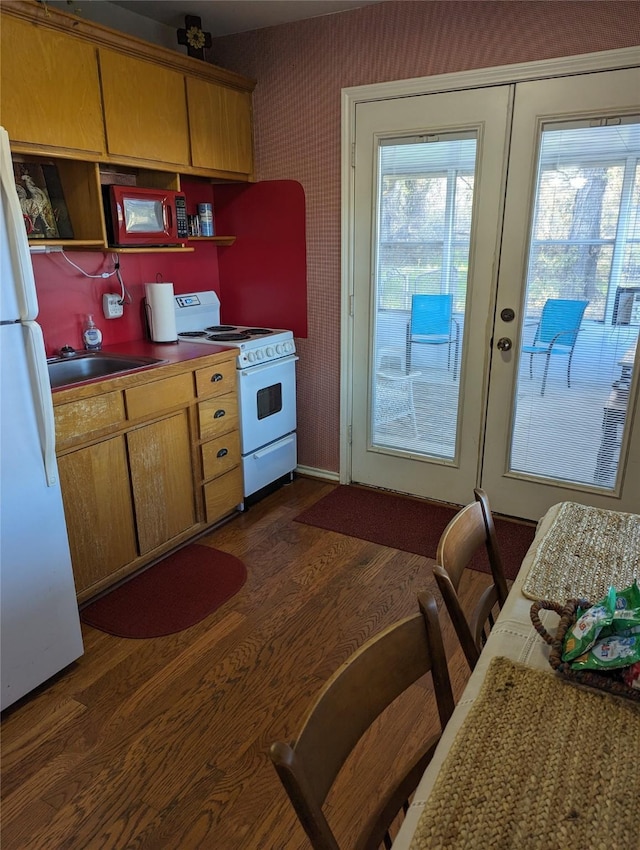 kitchen with french doors, dark hardwood / wood-style floors, white appliances, and sink