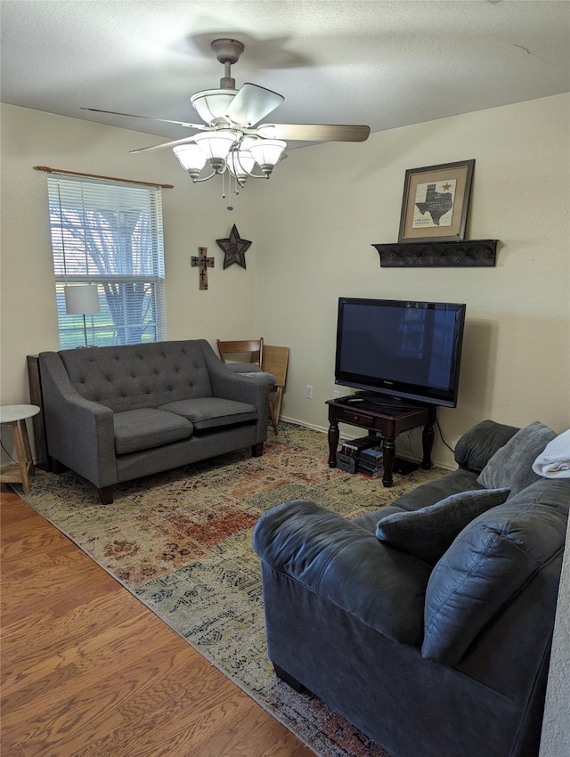 living room with wood-type flooring, a textured ceiling, and ceiling fan