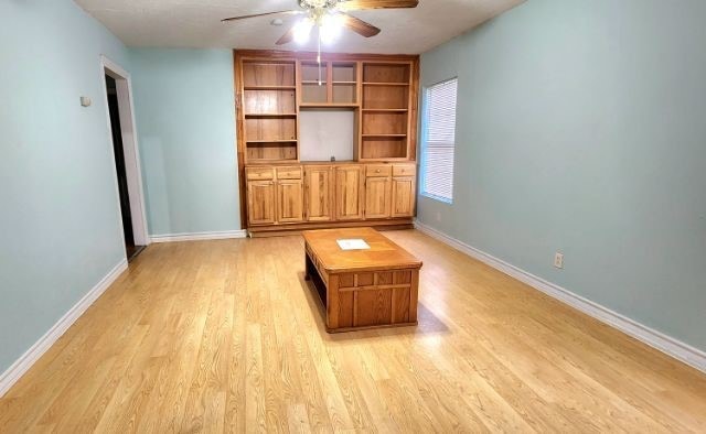 unfurnished living room with ceiling fan and light hardwood / wood-style flooring