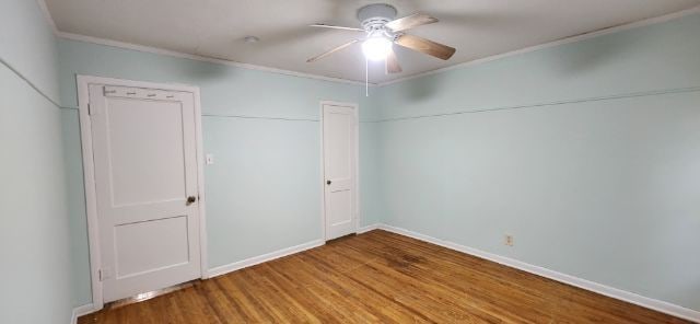 unfurnished bedroom with crown molding, ceiling fan, hardwood / wood-style floors, and a closet