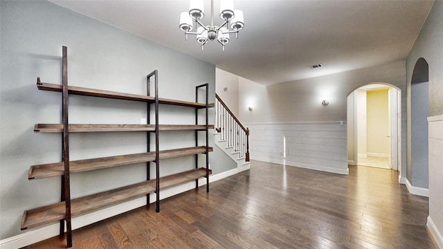 interior space featuring dark wood-type flooring and a notable chandelier