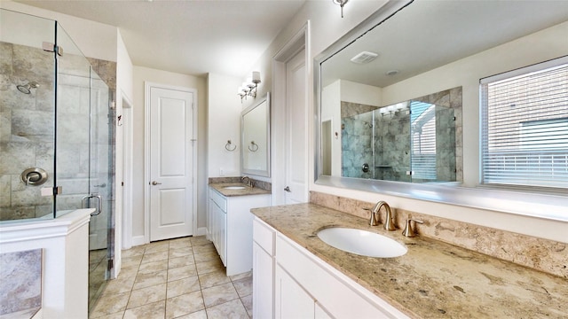 bathroom featuring tile patterned floors, vanity, and a shower with door