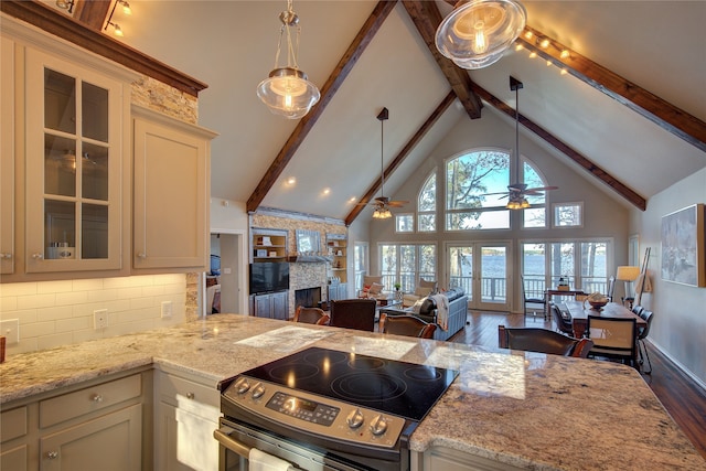 kitchen featuring stainless steel range with electric cooktop, ceiling fan, decorative backsplash, light stone countertops, and decorative light fixtures