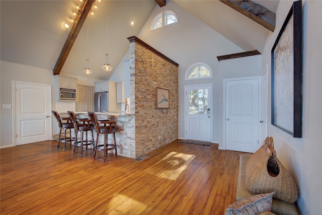 entrance foyer featuring beamed ceiling, high vaulted ceiling, and light hardwood / wood-style floors