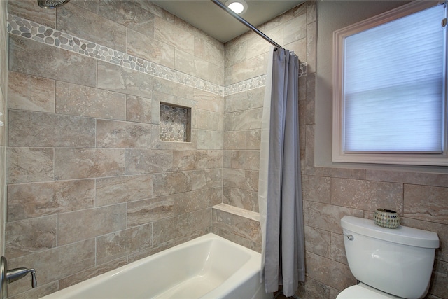 bathroom featuring shower / bath combo, toilet, and tile walls