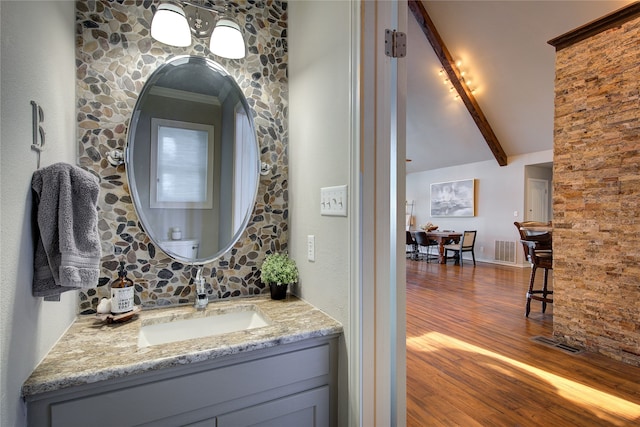 bathroom featuring crown molding, vanity, lofted ceiling with beams, and hardwood / wood-style flooring