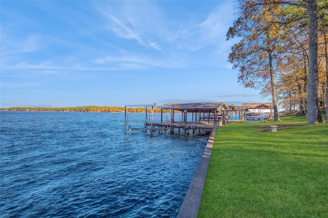 view of dock with a yard and a water view