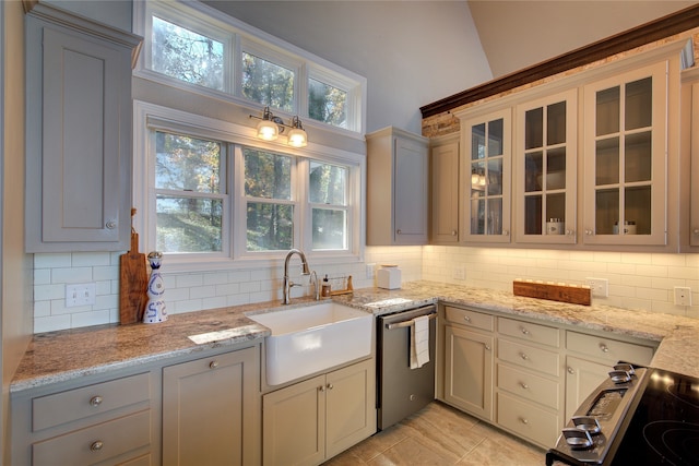 kitchen featuring gray cabinetry, sink, decorative backsplash, light stone countertops, and appliances with stainless steel finishes