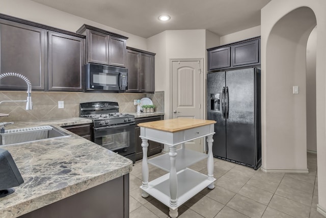 kitchen featuring dark brown cabinetry, sink, tasteful backsplash, light tile patterned flooring, and black appliances