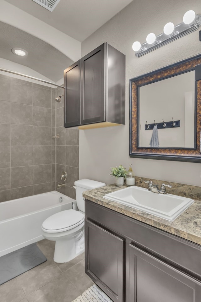 full bathroom with tile patterned floors, tiled shower / bath combo, toilet, and vanity