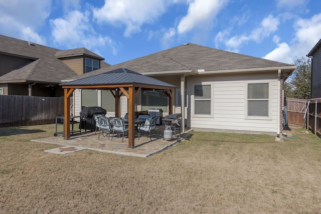 back of house with a gazebo, a patio, and a lawn