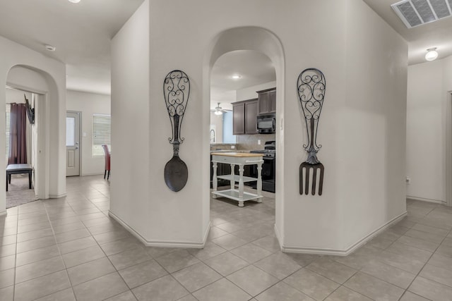 hall featuring light tile patterned floors