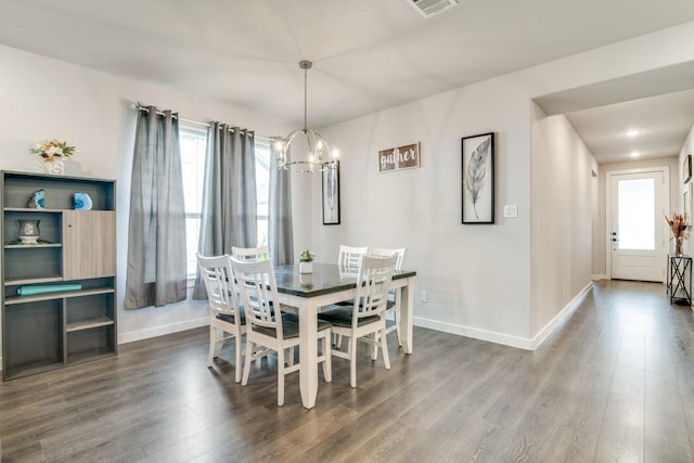 dining space featuring dark hardwood / wood-style floors and an inviting chandelier