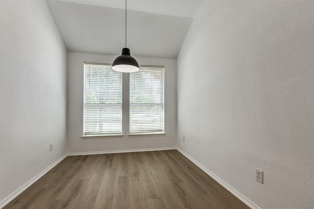 unfurnished dining area with dark hardwood / wood-style flooring and lofted ceiling