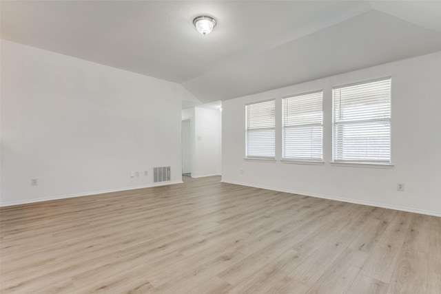 unfurnished room with light hardwood / wood-style flooring and vaulted ceiling