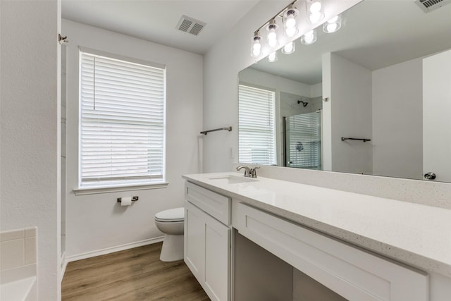 bathroom with toilet, vanity, an enclosed shower, and hardwood / wood-style floors