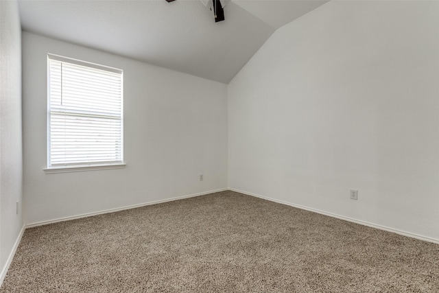 carpeted empty room with vaulted ceiling