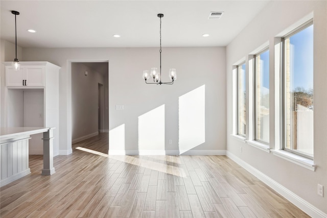 unfurnished dining area featuring a notable chandelier and a healthy amount of sunlight