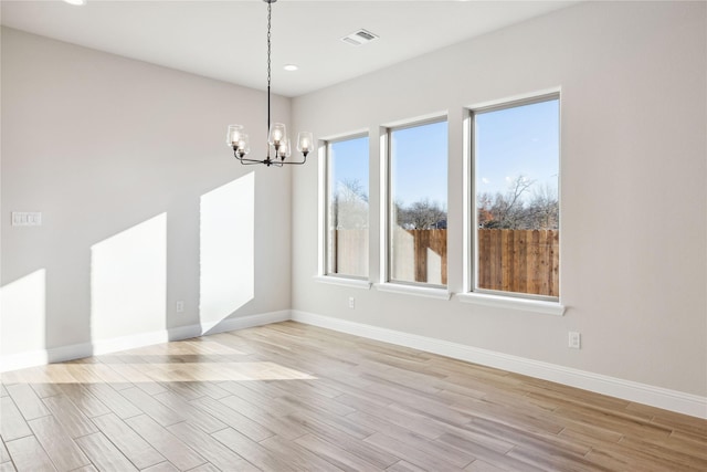 unfurnished dining area featuring plenty of natural light and an inviting chandelier