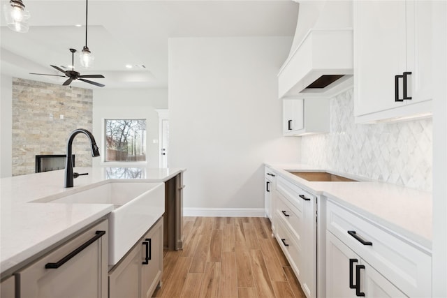 kitchen with white cabinets, pendant lighting, and custom exhaust hood