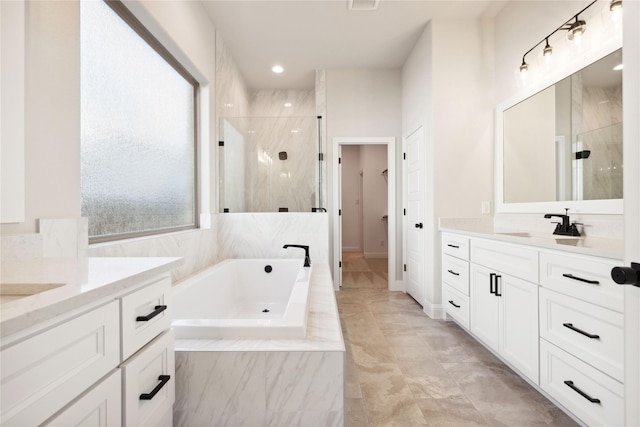 bathroom featuring vanity and independent shower and bath