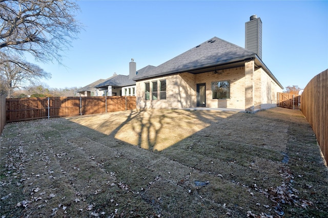 back of property featuring ceiling fan and a lawn