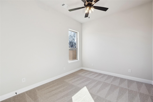 spare room featuring light colored carpet and ceiling fan