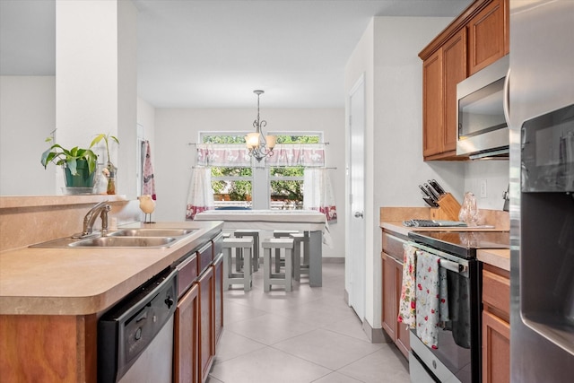 kitchen featuring hanging light fixtures, sink, appliances with stainless steel finishes, a notable chandelier, and light tile patterned flooring