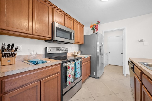 kitchen with light tile patterned flooring and appliances with stainless steel finishes