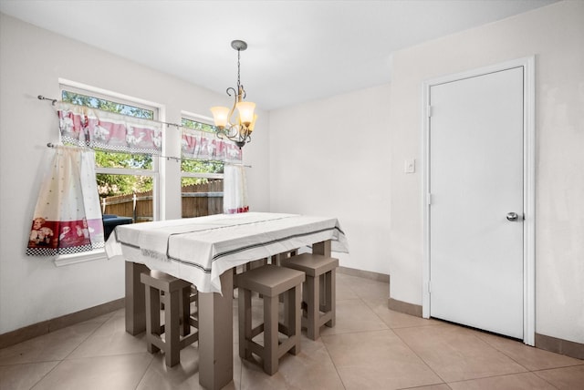 tiled dining room featuring a chandelier