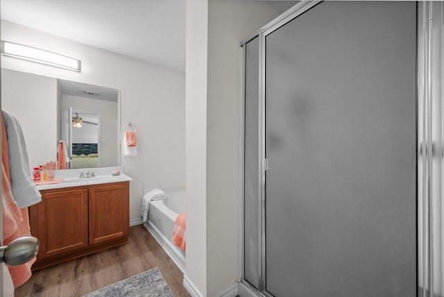 bathroom featuring vanity, hardwood / wood-style floors, and plus walk in shower