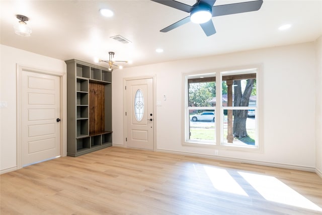 interior space featuring ceiling fan with notable chandelier and light hardwood / wood-style flooring