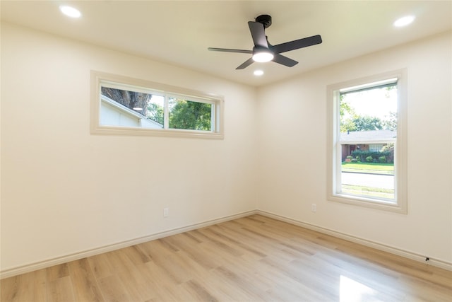 spare room with ceiling fan, light hardwood / wood-style flooring, and a wealth of natural light