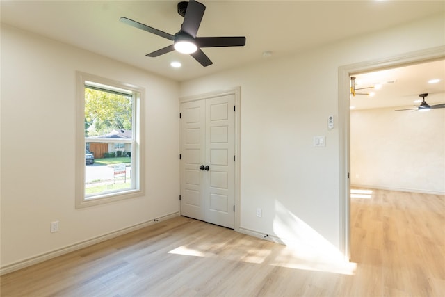 unfurnished bedroom featuring a closet, light hardwood / wood-style flooring, and ceiling fan