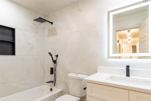 full bathroom featuring tiled shower / bath combo, toilet, and vanity