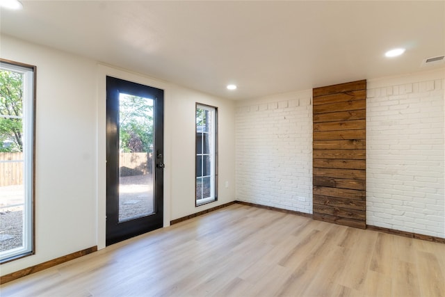 interior space with light wood-type flooring and brick wall