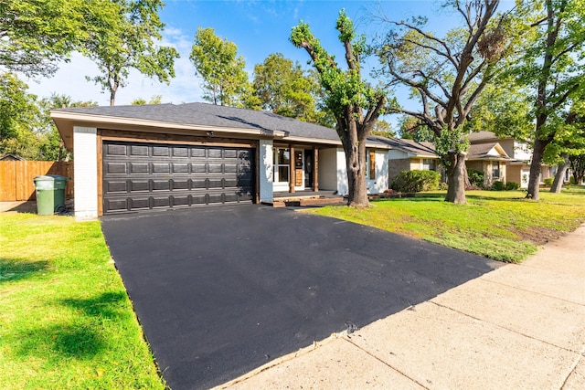 ranch-style home with a garage and a front lawn