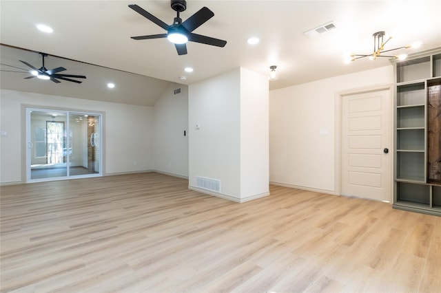 unfurnished room featuring ceiling fan with notable chandelier, light wood-type flooring, and vaulted ceiling