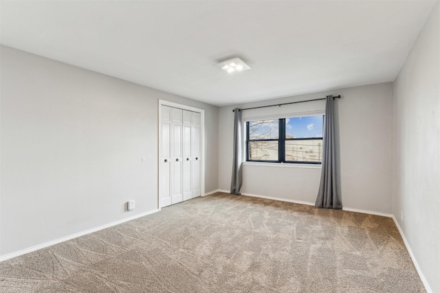 carpeted empty room featuring baseboards