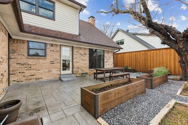 view of patio / terrace with a vegetable garden and fence