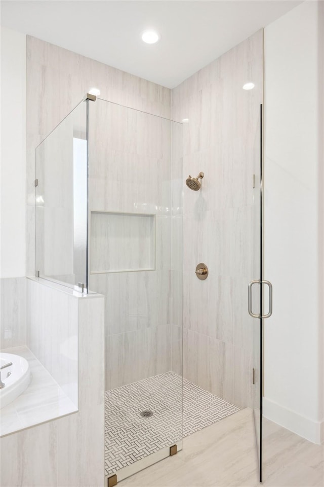 bathroom featuring hardwood / wood-style flooring and plus walk in shower