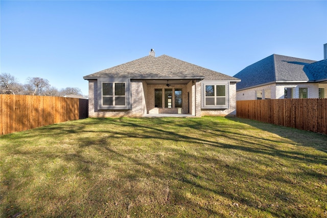 back of house featuring ceiling fan and a lawn