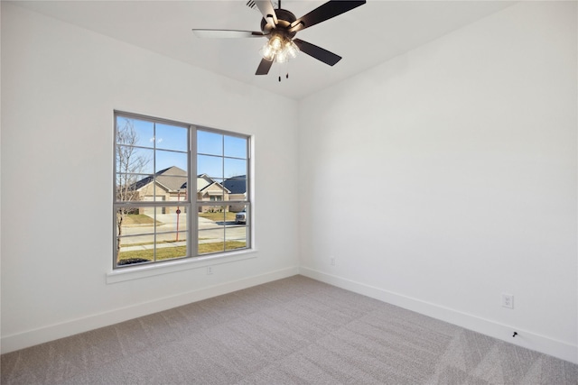 carpeted spare room featuring ceiling fan