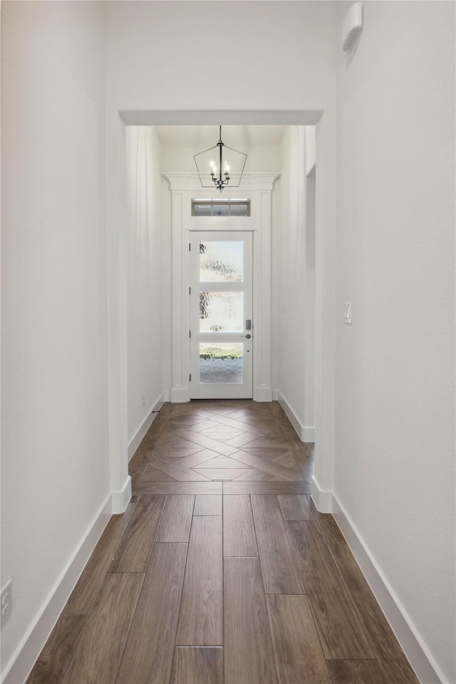 doorway to outside with hardwood / wood-style floors and an inviting chandelier