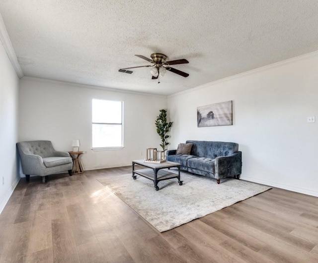 living room with ornamental molding, hardwood / wood-style floors, ceiling fan, and a textured ceiling