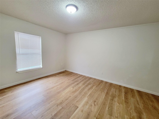 unfurnished room featuring a textured ceiling and light hardwood / wood-style flooring