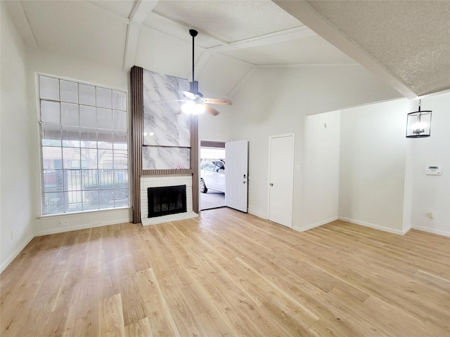 unfurnished living room with beam ceiling, light wood-style floors, and a healthy amount of sunlight