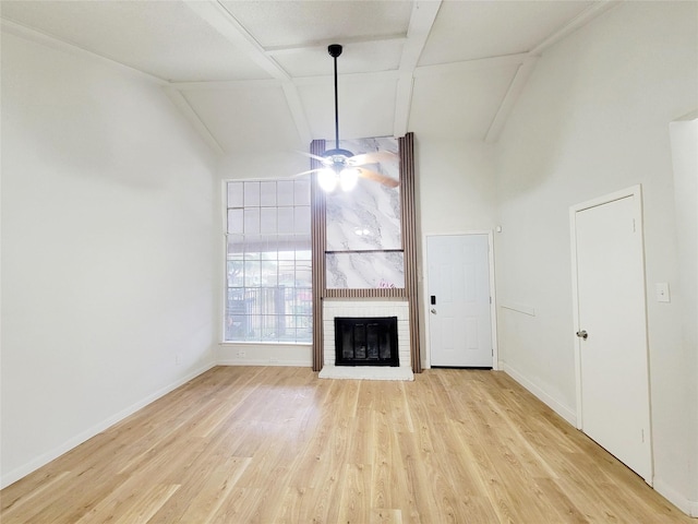 unfurnished living room featuring ceiling fan, a fireplace, lofted ceiling, and light hardwood / wood-style flooring