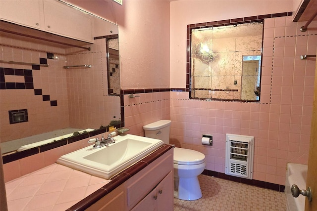 bathroom featuring vanity, toilet, tile walls, and heating unit