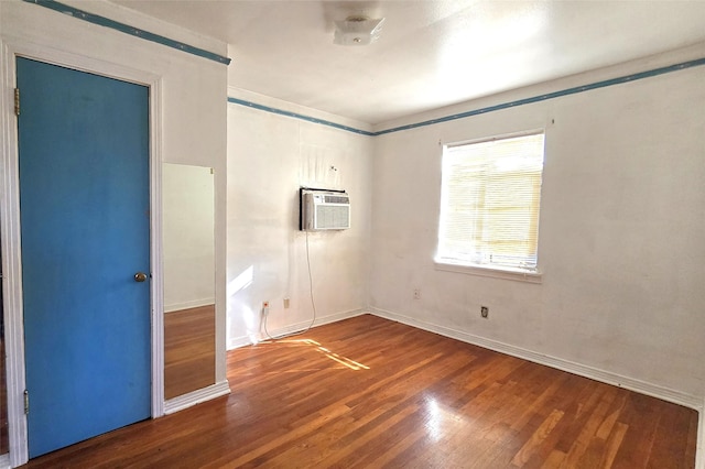 empty room featuring a wall mounted AC and hardwood / wood-style floors